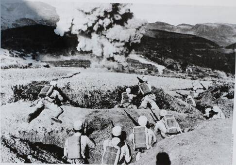 1944年,松山战役中,中国远征军士兵蹲伏在壕沟里,前方,一枚炮弹正在