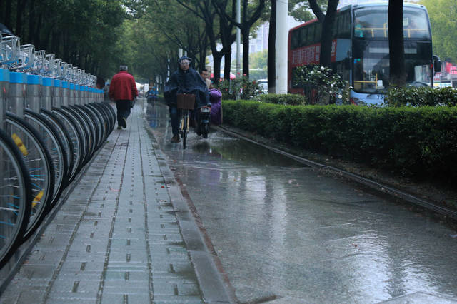 下雨天的,一边打伞,一边骑车,看着都为你捏了一把汗.