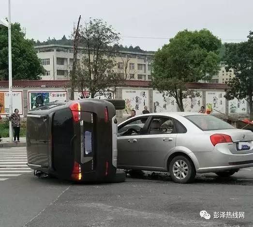 今天下午彭泽一中路口发生一起交通事故,黑色轿车侧翻