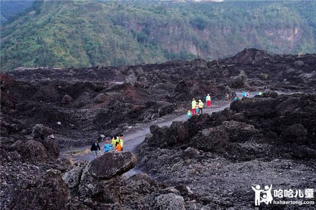 行走在火山脚下的碎石和焦土上,黑色的火山岩和不远处的巴图尔火山给