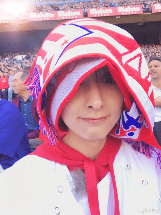 " 照片中的吴昕戴一条球队围巾,和足球场鲜红的颜