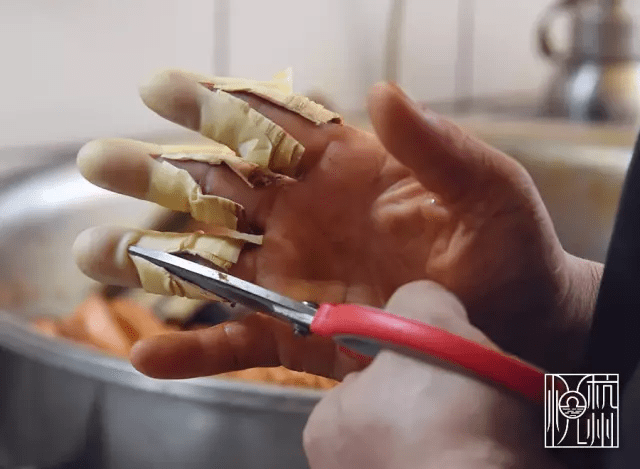 每天包完粽子后,右手上的手指套要用剪子剪才能脱下.