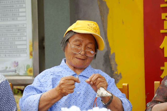 海宁一群近90岁老太太 街头针线活做香包送路人