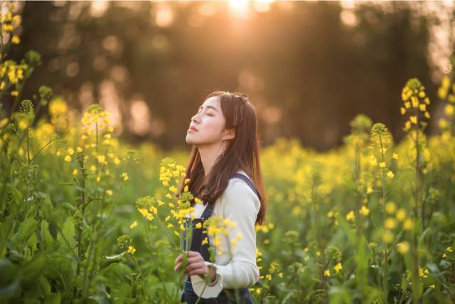 前景花儿明艳,后景人儿恬静美丽.