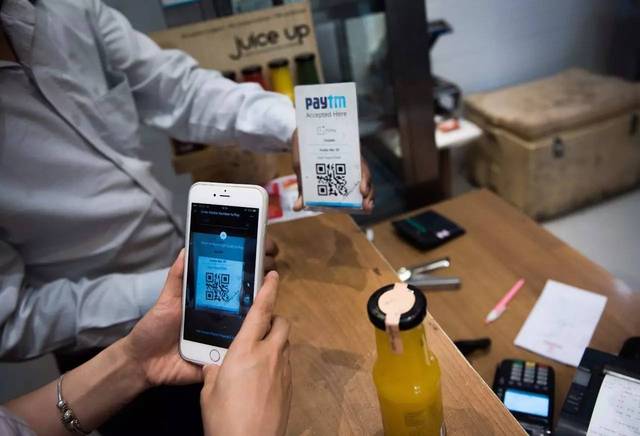 顾客在印度新德里一家甜食店扫描 paytm 二维码付款