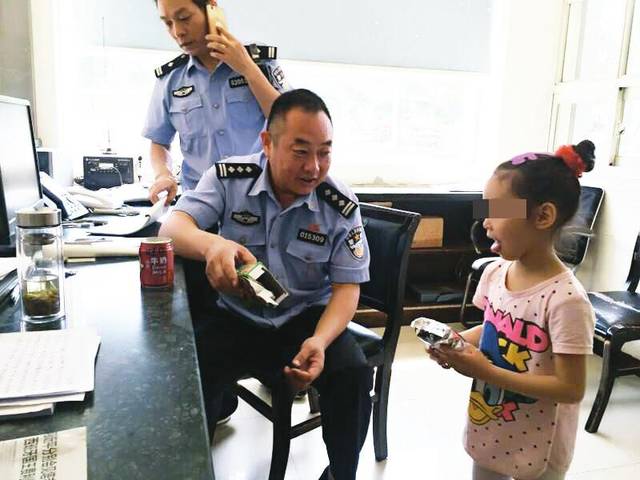 民警在派出所里询问小女孩家庭情况