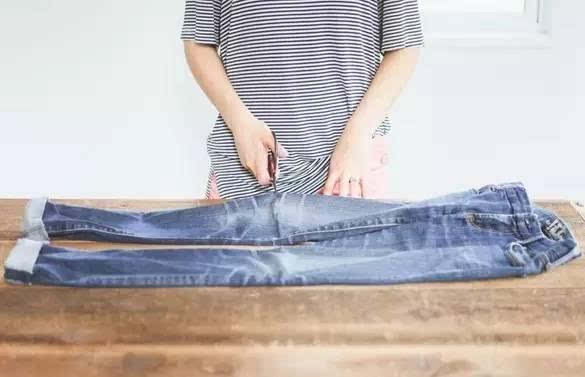 用剪刀先将你牛仔裤的膝盖部位(或者任何你想要制作破洞的位置)剪出一