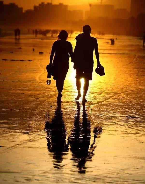 日落时分,红霞满天,与相爱的人一同走在柔软的沙滩上,浪漫极了