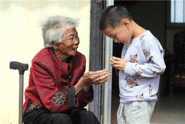 老人特别喜欢孩子,家里来了小孩她都会逗孩子玩,拿出零食给孩子吃.