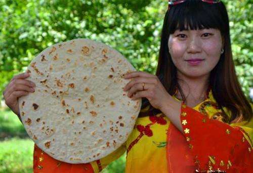 锡伯族女人是制作锡伯大饼的能手,揉面,擀面,烤饼,然后将面饼挂在