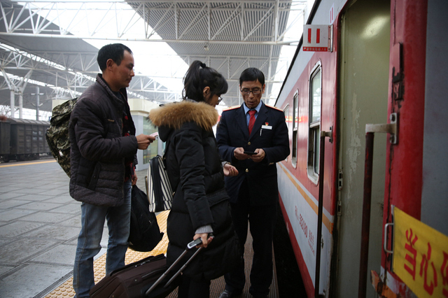 刘金龙正在查验旅客车票(胡景张红民文/摄)