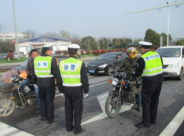 一辆无牌照的摩托车在路口被交警拦下