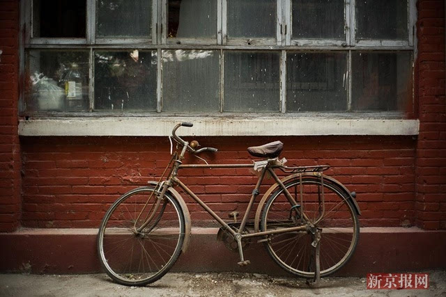 2017年5月2日,幸福北里,一辆锈迹斑斑的老式自行车停在一栋老居民楼前