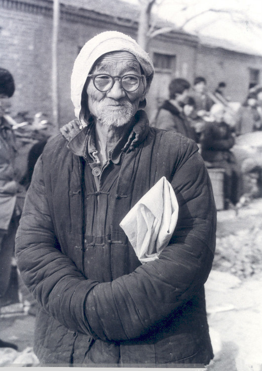 1982年的农村生活场景:一位老人带着口袋子准备在集镇上买点物品