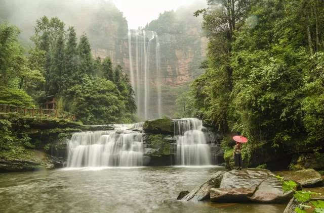 6月18日,江津区四面山景区,一名游客凝视望乡台瀑布.张树仁 摄