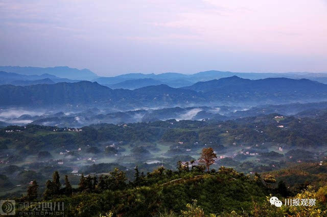 7月10日,一名游客在打古镇普照山风景区拍摄朝阳.杨涛 摄