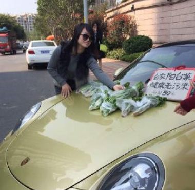 3月27日上午,一女子驾驶一辆金色保时捷跑车在仓山一小区门口摆起菜