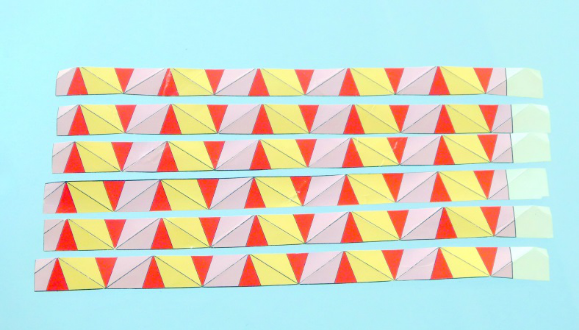 从材料模板上剪下六条纸条,再在每条纸带的每条长黑线上做出山形折痕