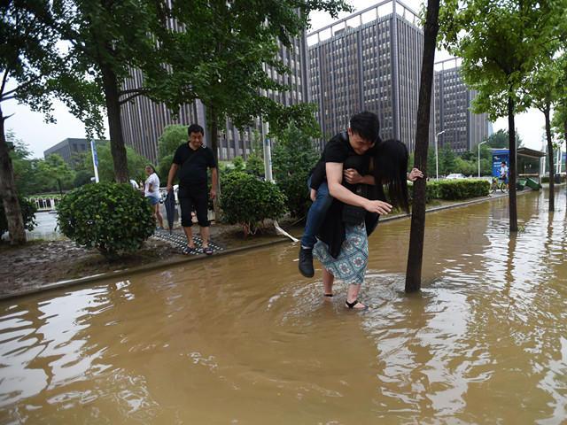 武汉一女孩不让男友湿鞋 直接背其淌水过马路
