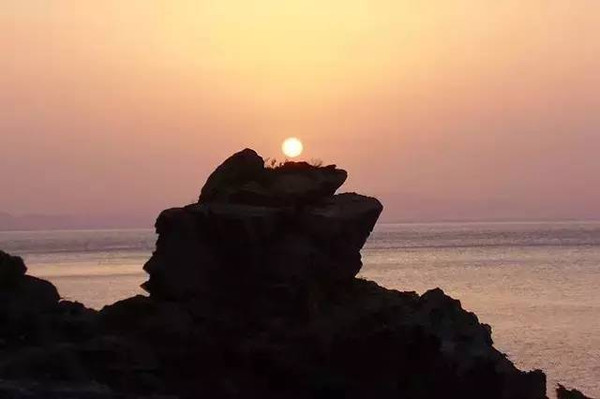 太阳从海平面升腾而出,美丽的灵山岛令人神往.山高海阔,景象万千.