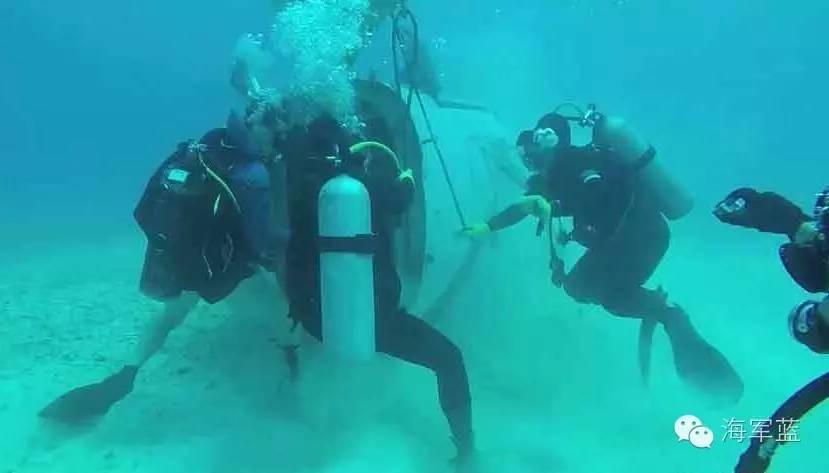 潜水打捞队员正对直升机零散残骸等沉物进行水下测量作业.