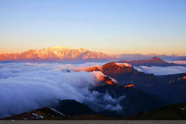 山峰沐浴在金色光辉中，金色光辉下的山峰美景