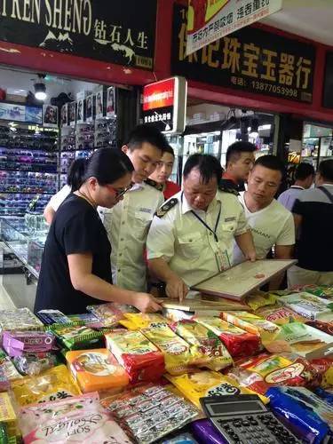 图为东兴市食品药品监管人员在越南特色商品一条街检查食品经销商持证