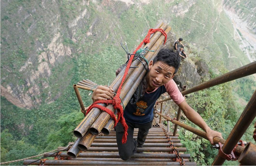 四川凉山悬崖村绝壁修路 村民背1500根钢管上山造天梯