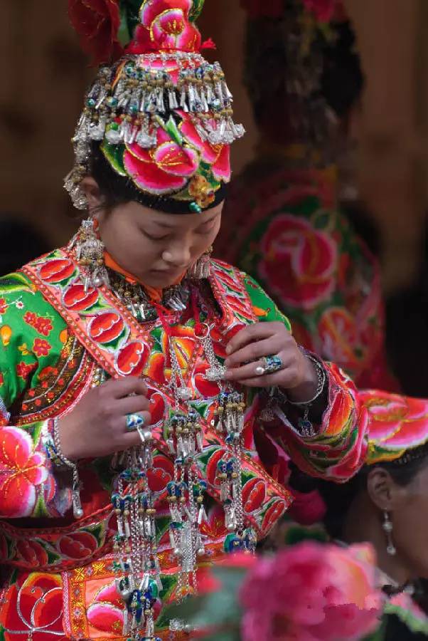 喜庆的红色上满装饰有花朵 还有各种寓意吉祥的图案 据说彝族女孩 从