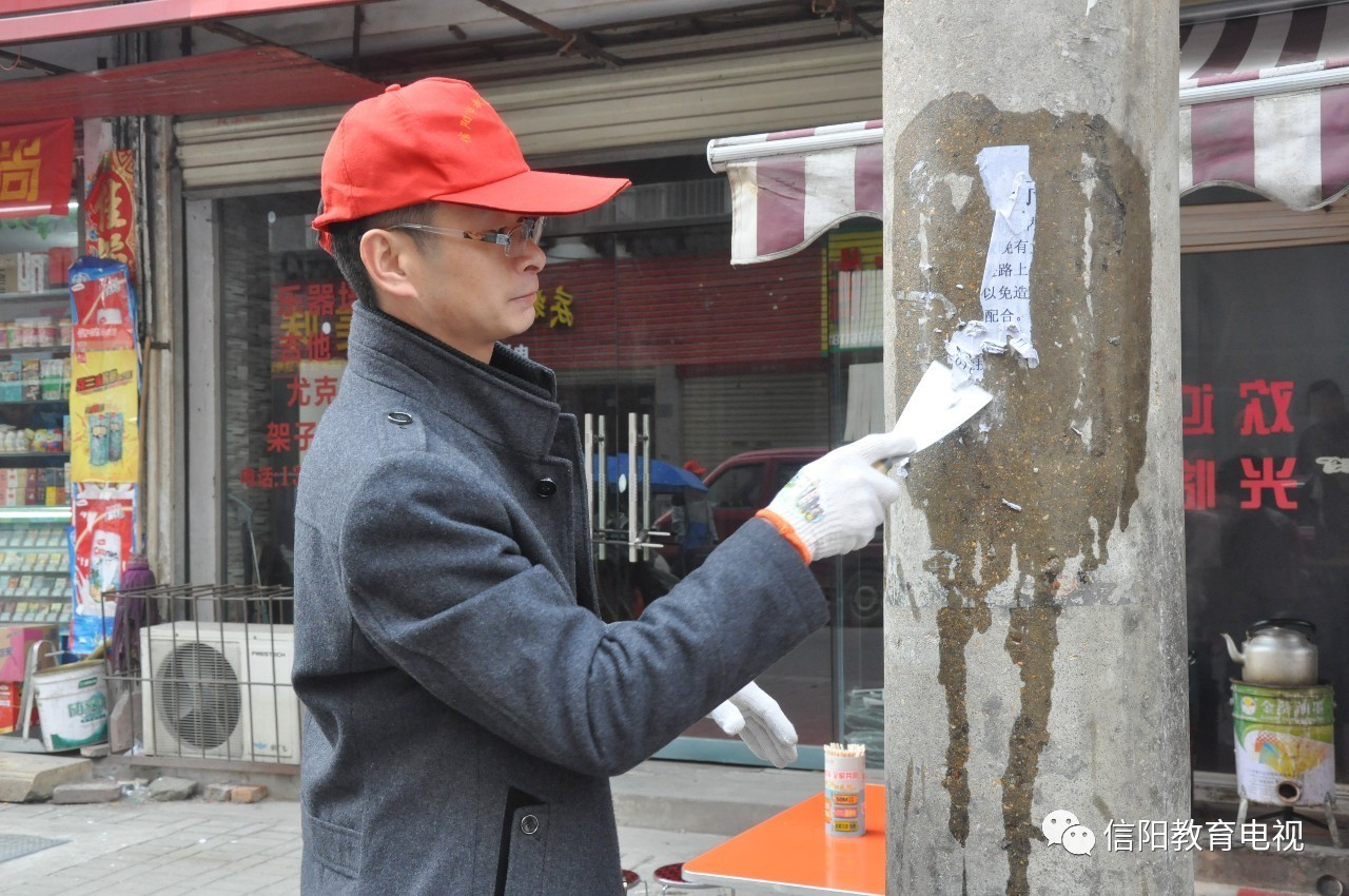 清理城市"牛皮癣 信阳市教育电视台志愿者在行动