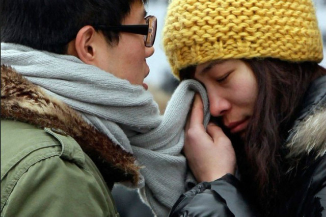 2012年1月19日,北京西站,一对情侣分别时,女孩用男孩的围巾擦泪.