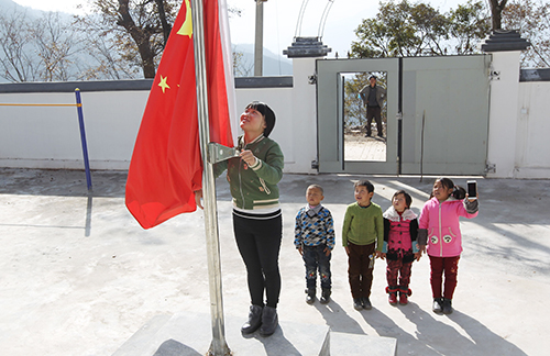 张军燕和四个孩子升国旗（图片来源：中国教育报）