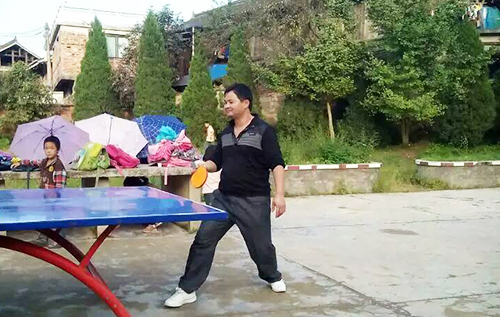 图为吴尚兴和同学们打乒乓球