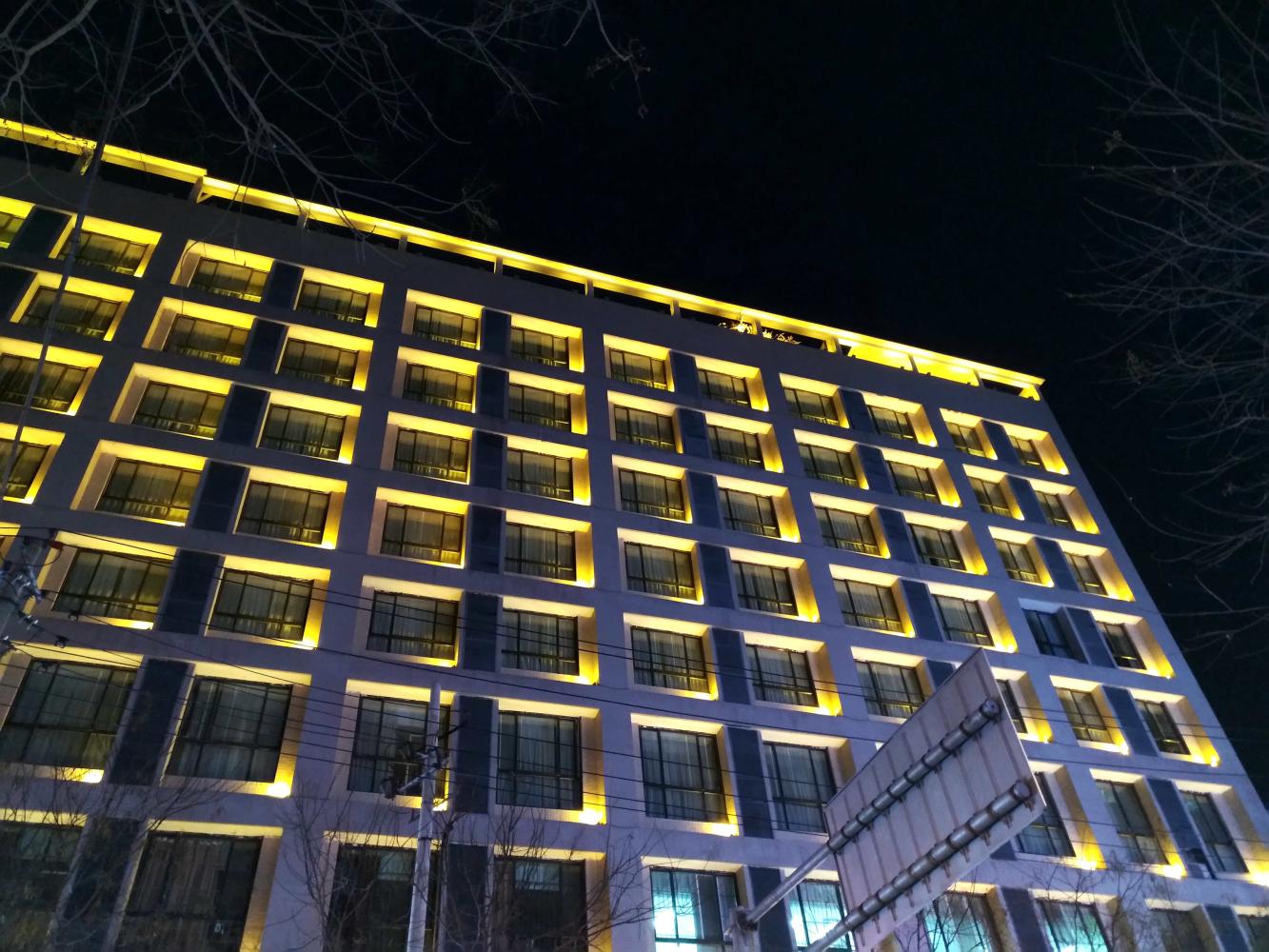 夜景模式拍摄酒店外墙部分,黄色的灯光整齐划一的抓取,角落里面的
