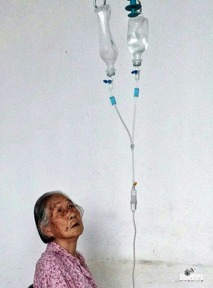 7月16日,正在输液的母亲抬头看着吊瓶,对治好自己的病还充满信心.