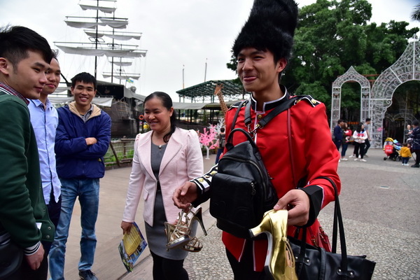 佛山男导游含筷子练微笑在景区门口鞠躬迎接女游客