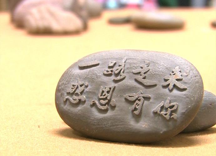 殷彬在一块石头上雕刻下了八个字"一路走来,感恩有你!"