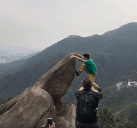比如这样的:视频中,一位绿衣男青年在悬崖上做着一系列危险的动作.