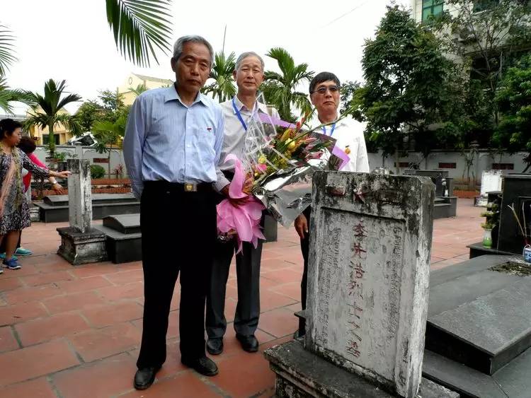 返越访问的战友拉起祭幛在烈士碑前留影与越南嘉林烈士陵园管理处的