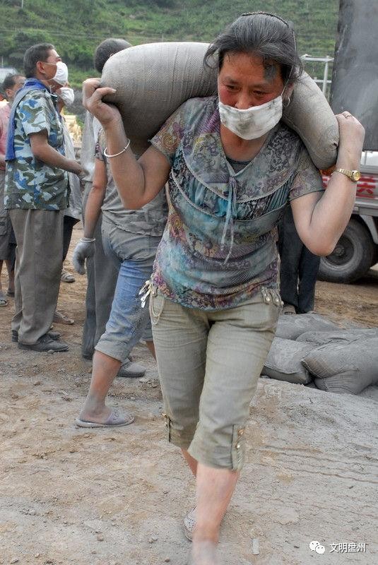 图中的女人一个人就能扛上一大包水泥,应该没有几个人能做到吧?