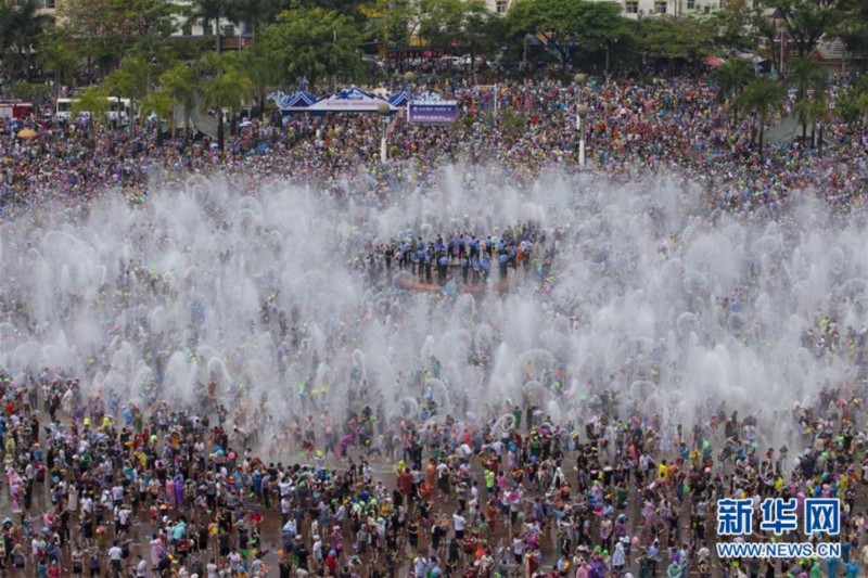 4月15日,一名外国游客在西双版纳景洪泼水广场参加泼水狂欢.