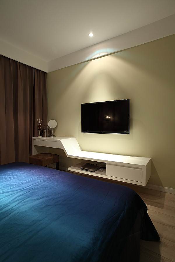 将电视悬挂在墙壁上,卧室的电视柜也是依靠着墙壁设计,采用 高低的