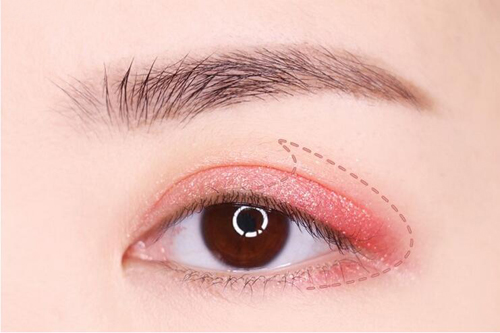 step2:在浅粉色珠光眼影上覆盖上桃红色珠光眼影,并在眼尾的三角