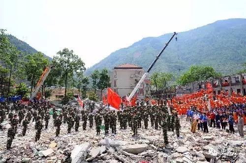 5月19日14时28分,在北川中学救援现场,搜救人员向汶川大地震遇难者