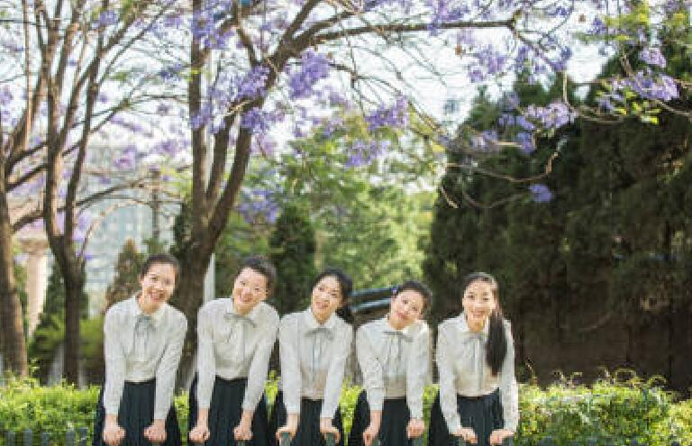 照片上满树蓝花楹为背景,五名女学生穿姐妹装合拍,极为亮眼.