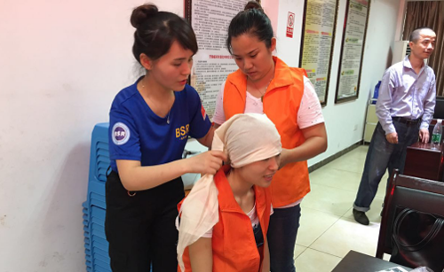 教官给志愿者们示范三角巾如何包扎受伤的头部