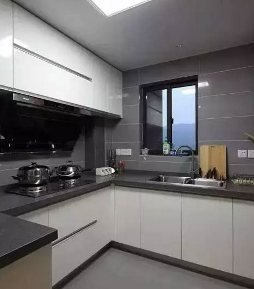厨房里的颜色搭配非常恰当,白色的橱柜门与深灰色的台面,浅灰色的墙面