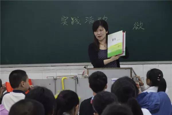 李红英向学生们展示学生作业优秀模板李红英是一名教师,现任实验小学