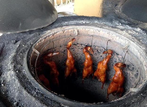 新鲜出炉的天香烤鸭出炉了烤鸭放在松树做成的砧板上砍切香喷喷的