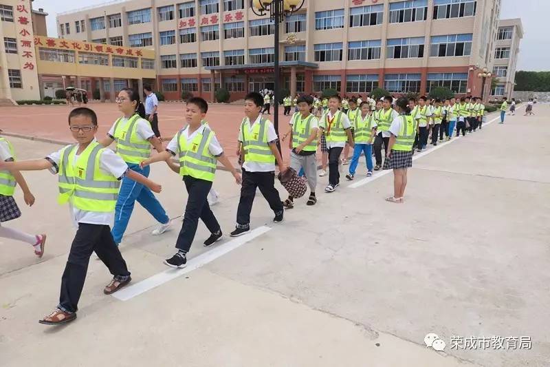 今天在世纪小学,同 学们穿着崭新的荧光衣,排着整齐的队伍有序上下学!